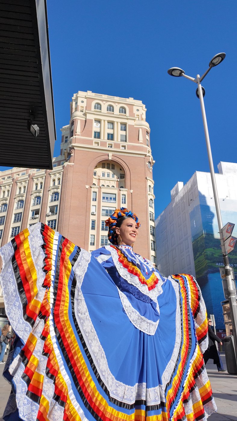 Bailarina con traje de jalisco frente al edificio Capitol de Gran Vía, en Madrid