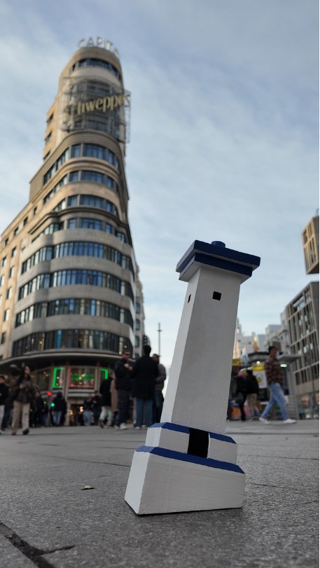 Maqueta de un faro de Puerto Morelos en la calle, con el edificio Capitol de fondo
