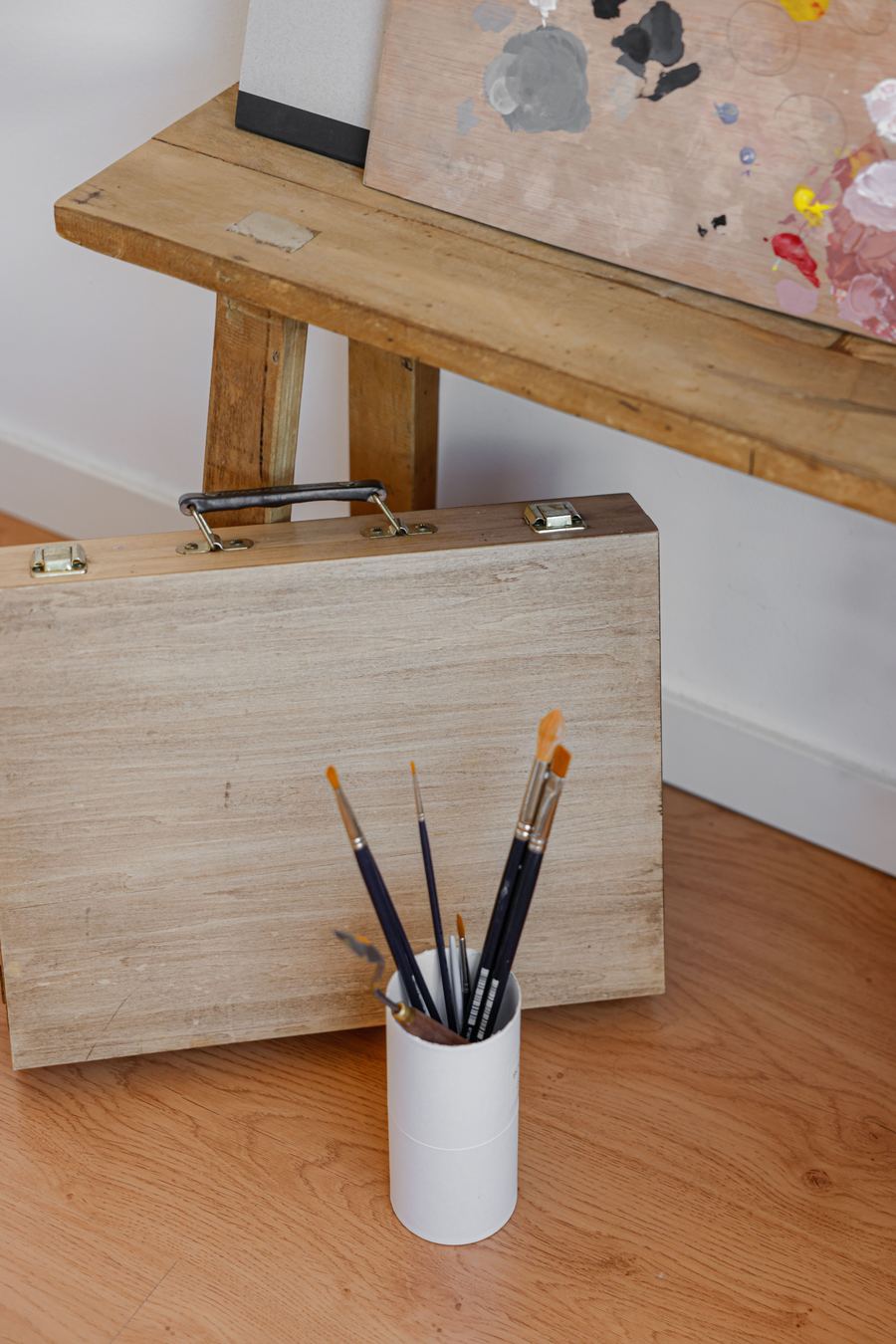 Pinceles de pintura sobre una caja de madera, en un estudio